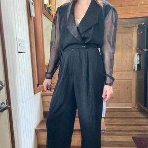 Black tuxedo style jumpsuit with sheer sleeves and fitted waist